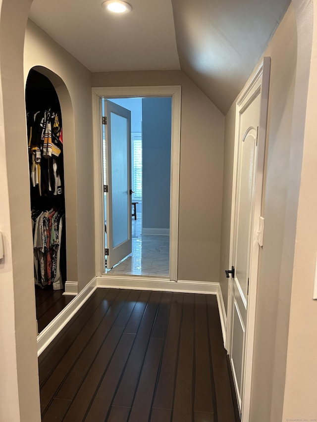 corridor with baseboards, lofted ceiling, dark wood finished floors, and recessed lighting