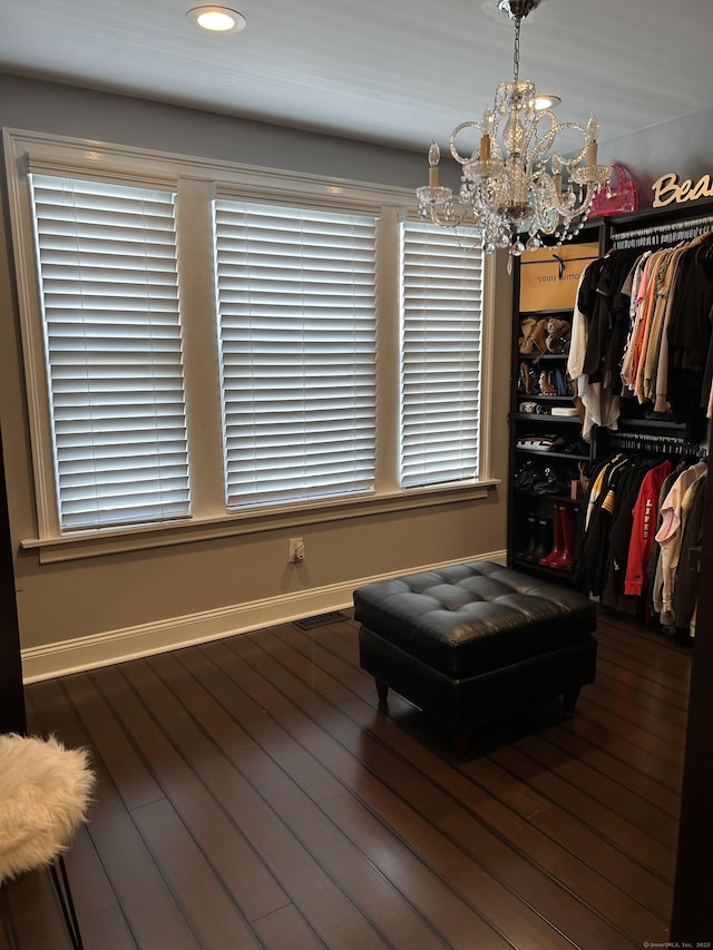spacious closet with a chandelier and wood finished floors