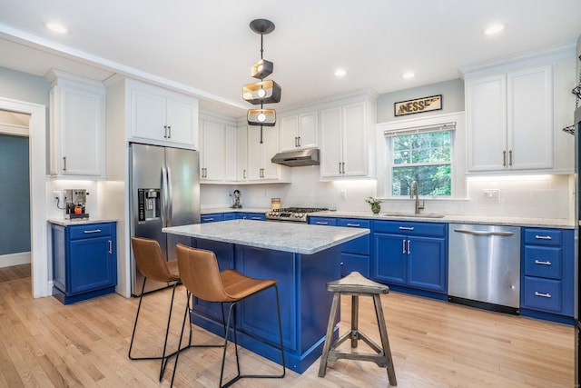 26 Ridgewood Rd, West Hartford, CT 06107 - kitchen featuring appliances with stainless steel finishes, a sink, under cabinet range hood, blue cabinetry, and light wood-style flooring