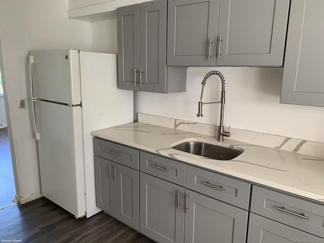 kitchen featuring gray cabinets, a sink, and dark wood-type flooring