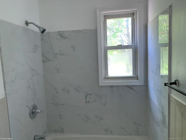 bathroom featuring healthy amount of natural light and bathing tub / shower combination