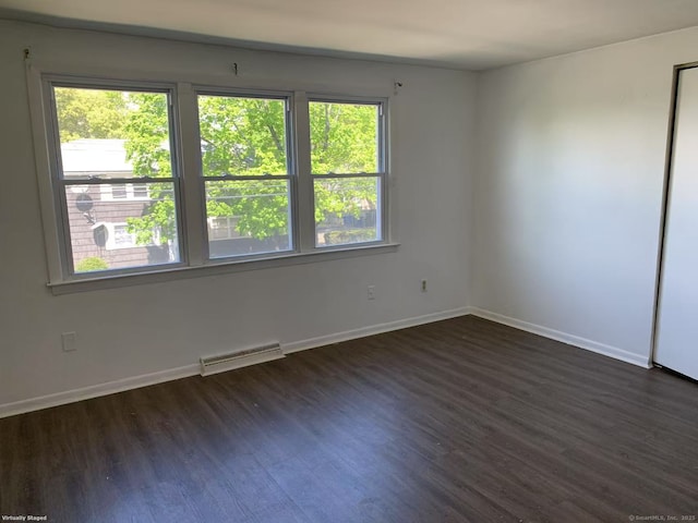 spare room with dark wood finished floors and baseboards