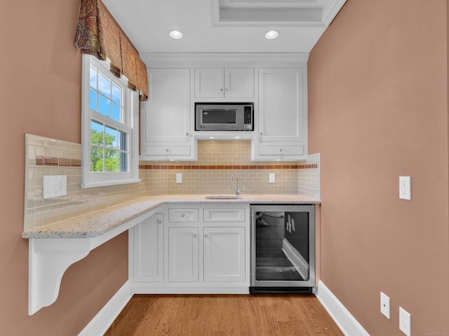 226 Alberta St, Fairfield, CT 06825 - kitchen with stainless steel microwave, beverage cooler, light wood-style floors, white cabinetry, and recessed lighting