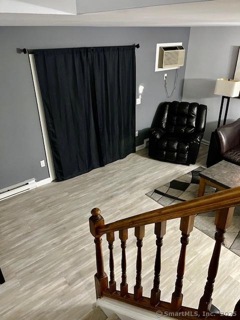 6 Hakim St Unit 2-6, Danbury, CT 06810 - living area with an AC wall unit, light wood-type flooring, baseboards, and a baseboard radiator