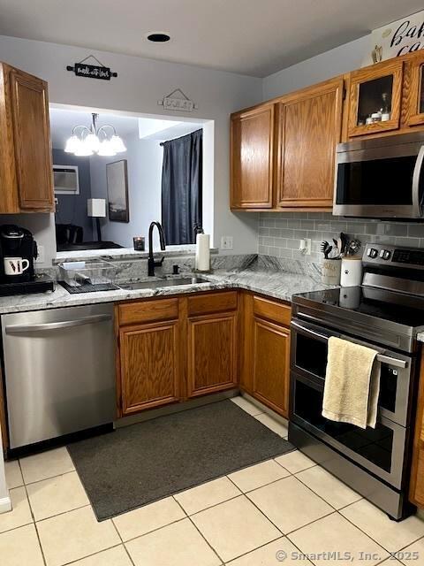6 Hakim St Unit 2-6, Danbury, CT 06810 - kitchen with appliances with stainless steel finishes, a sink, brown cabinetry, and a chandelier