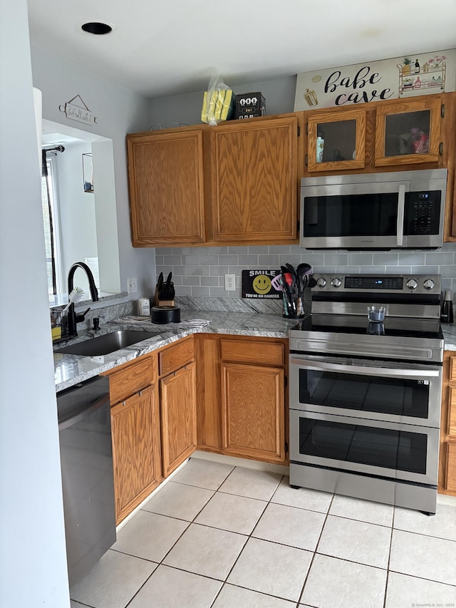 6 Hakim St Unit 2-6, Danbury, CT 06810 - kitchen with appliances with stainless steel finishes, a sink, backsplash, light stone countertops, and light tile patterned flooring