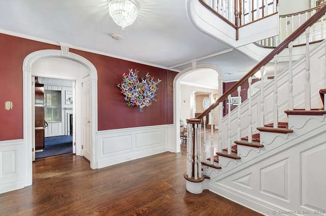 37 Hunting Hill Rd, Woodbridge, CT 06525 - entryway featuring arched walkways, wood finished floors, stairs, a wainscoted wall, and ornamental molding