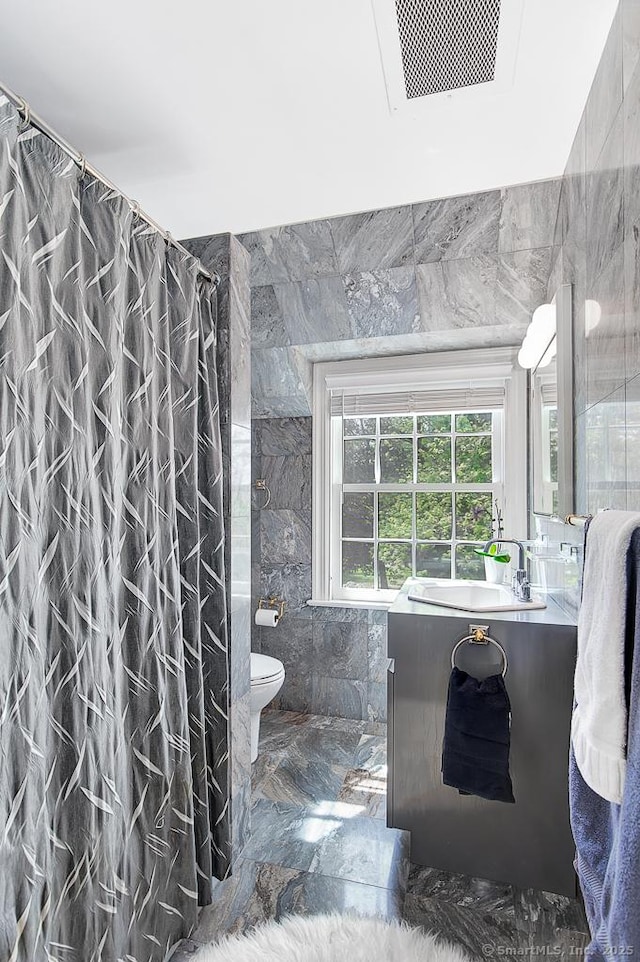 37 Hunting Hill Rd, Woodbridge, CT 06525 - full bath with tile walls, toilet, vanity, marble finish floors, and a shower with shower curtain