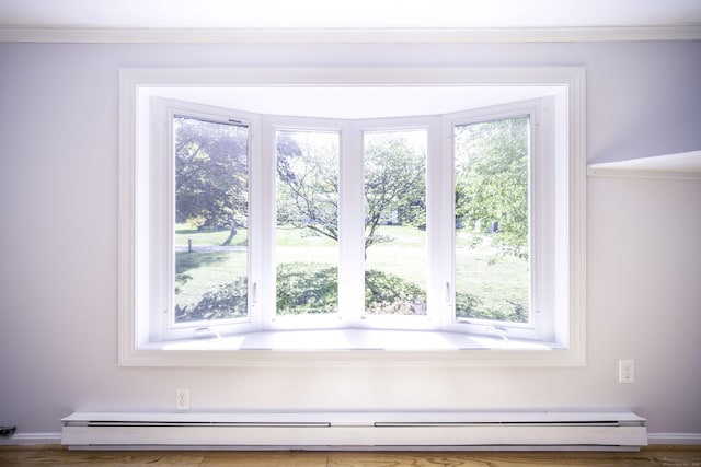 detailed view of a baseboard heating unit, ornamental molding, and baseboards