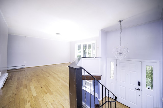 foyer entrance featuring a baseboard radiator, a chandelier, wood finished floors, and ornamental molding