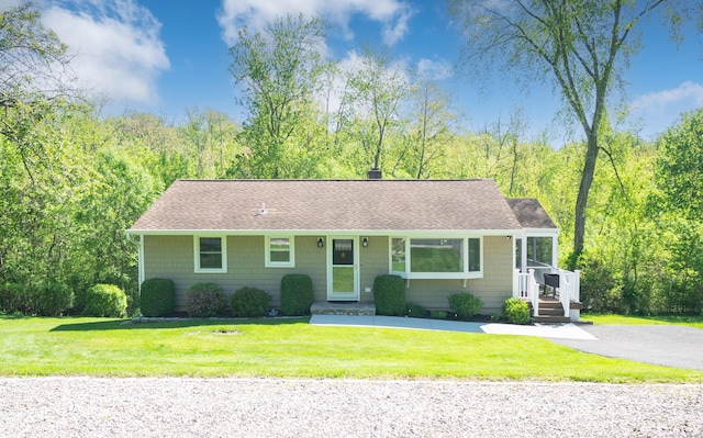view of front of house with a shingled roof and a front yard