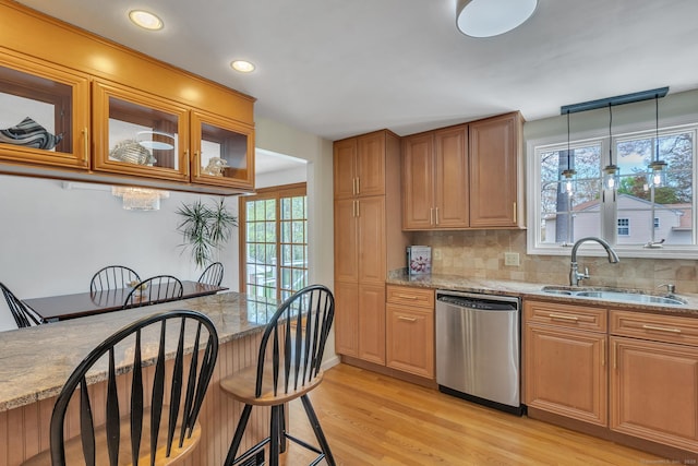 kitchen with stainless steel dishwasher, a sink, light wood-style floors, plenty of natural light, and recessed lighting