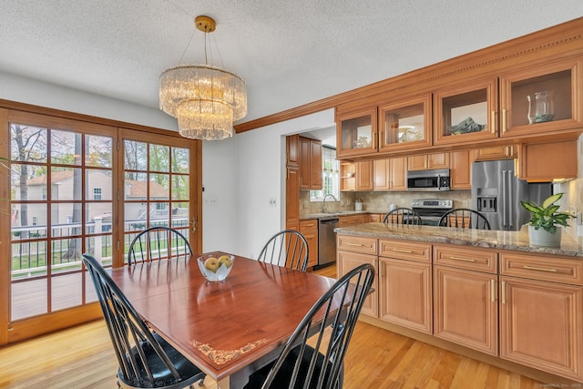 dining room featuring a chandelier, light wood finished floors, and a textured ceiling