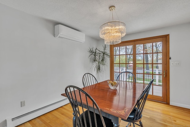 dining room with a baseboard radiator, a chandelier, a wall mounted AC, light wood-style floors, and a textured ceiling