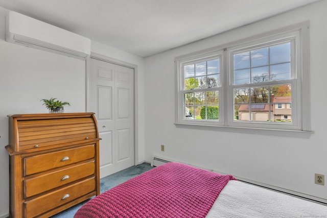 carpeted bedroom featuring an AC wall unit, a closet, and a baseboard heating unit