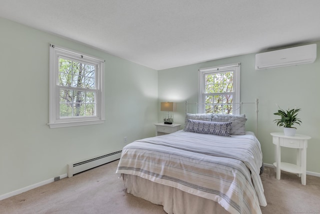 bedroom with baseboard heating, a wall unit AC, carpet floors, and baseboards