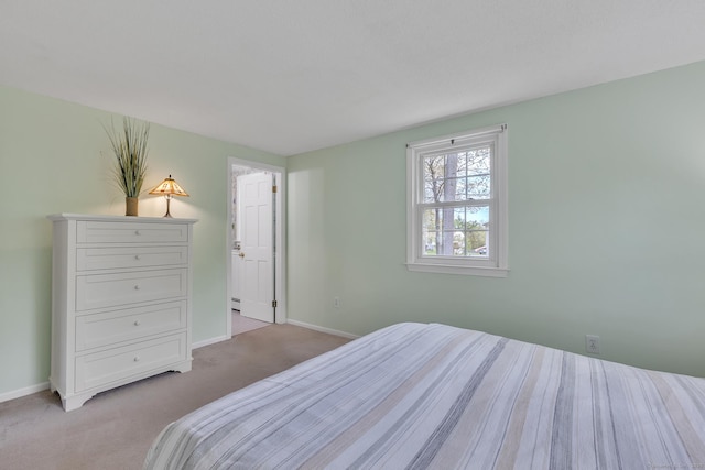 bedroom featuring light colored carpet, baseboards, and a baseboard heating unit