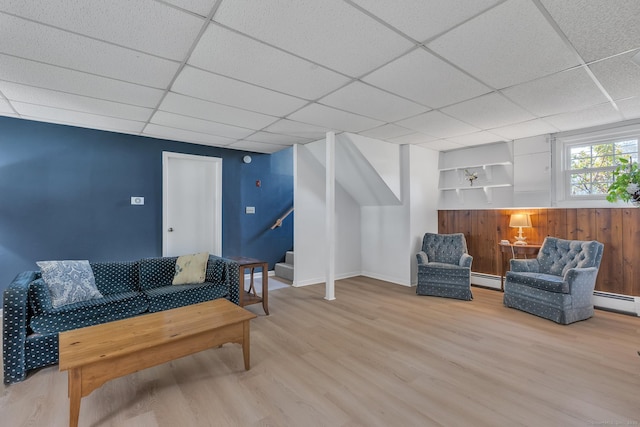 living room featuring wood finished floors, a paneled ceiling, stairway, and baseboard heating