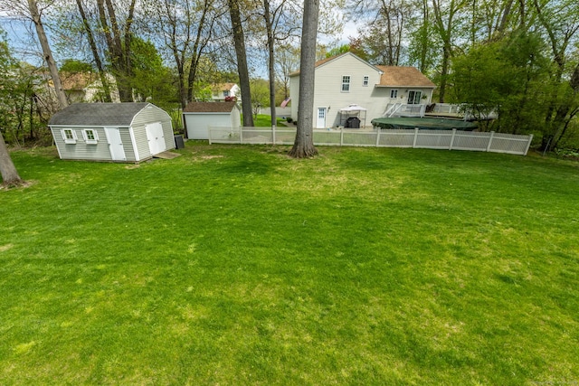 view of yard featuring a storage shed, an outdoor structure, and a deck