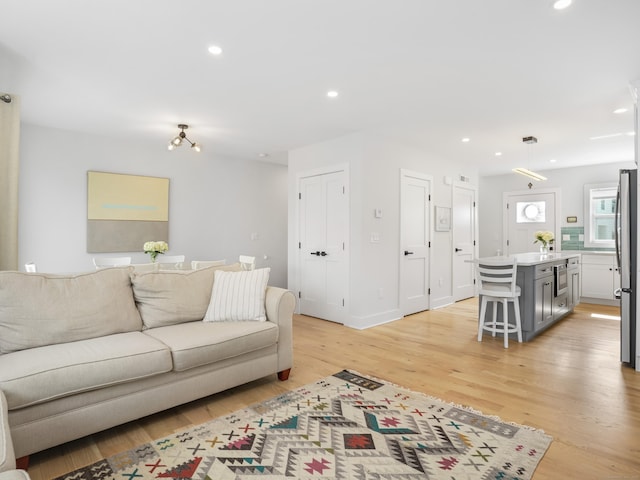 living area featuring light wood-type flooring and recessed lighting