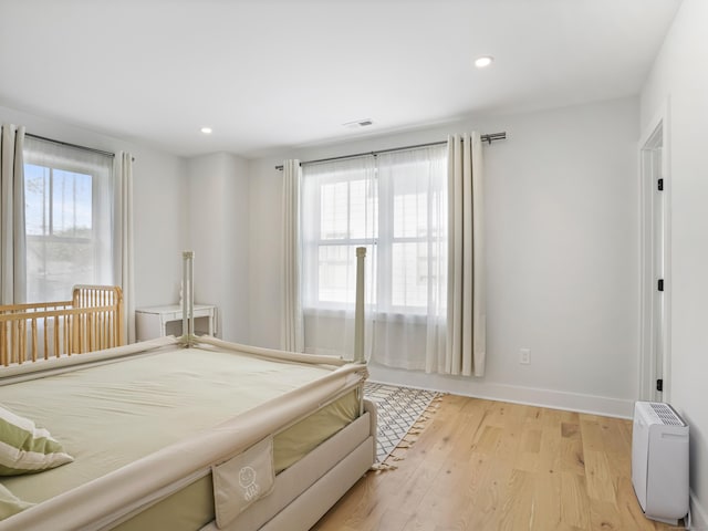 bedroom with recessed lighting, light wood finished floors, and baseboards