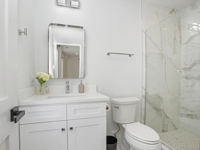 bathroom with a marble finish shower, toilet, and vanity