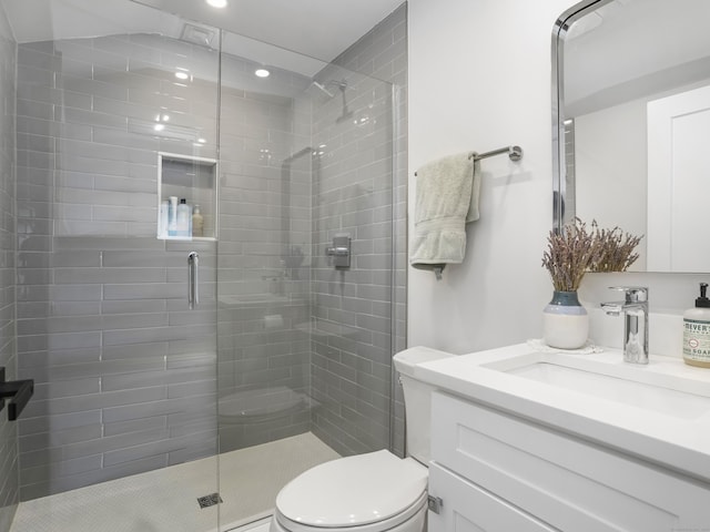 bathroom featuring toilet, a shower stall, recessed lighting, and vanity