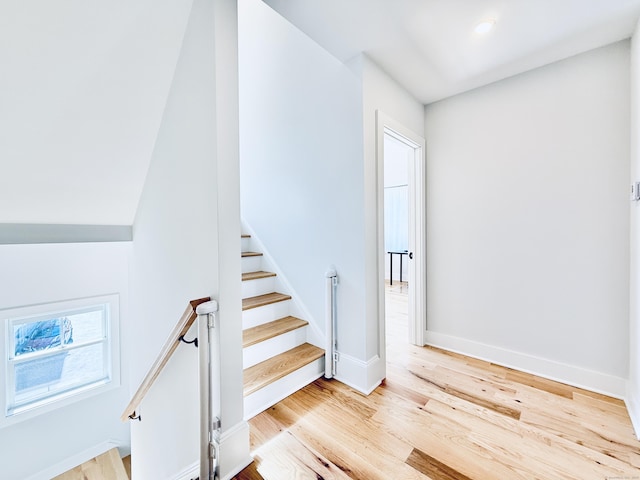 stairway featuring baseboards and wood finished floors