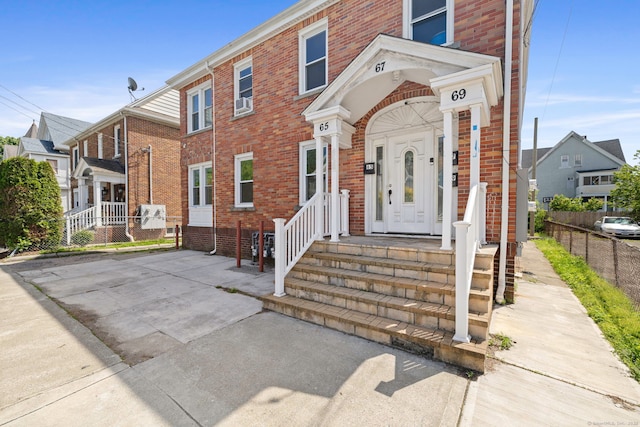 townhome / multi-family property with brick siding and fence
