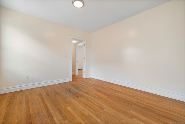 unfurnished room with baseboards and light wood-style floors