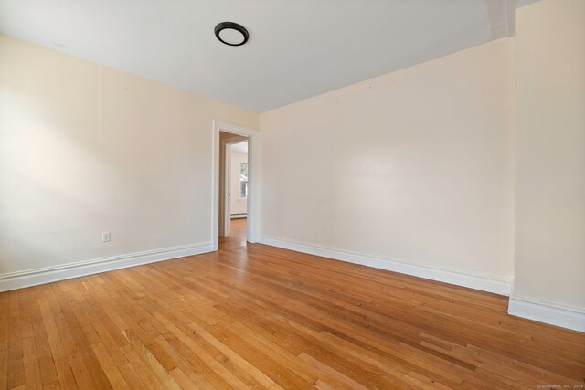 unfurnished room featuring light wood-style flooring and baseboards