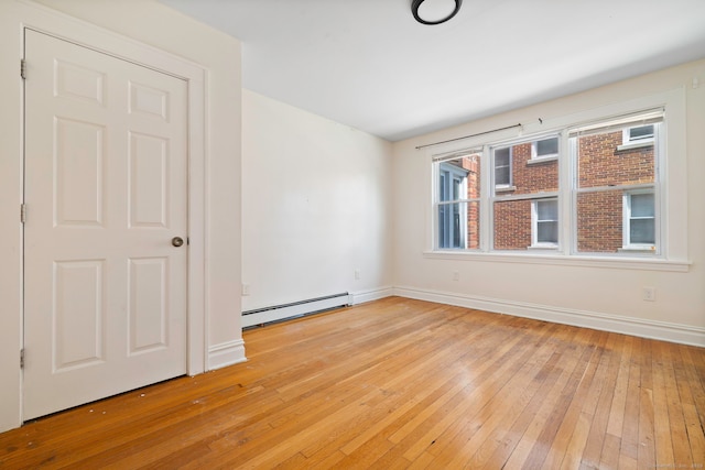 unfurnished room featuring a baseboard radiator, light wood-style flooring, and baseboards