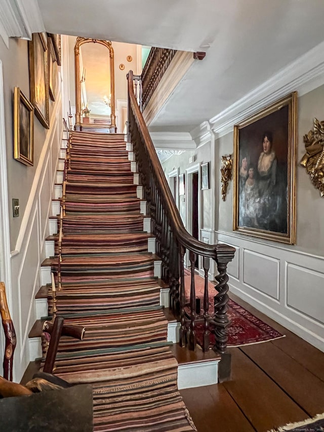 1066 Washington St, Middletown, CT 06457 - staircase featuring a decorative wall, crown molding, wood finished floors, and a wainscoted wall