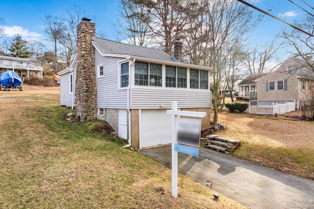 170 Giants Neck Rd, East Lyme, CT 06357 - view of front of house with a chimney, driveway, an attached garage, a sunroom, and roof with shingles