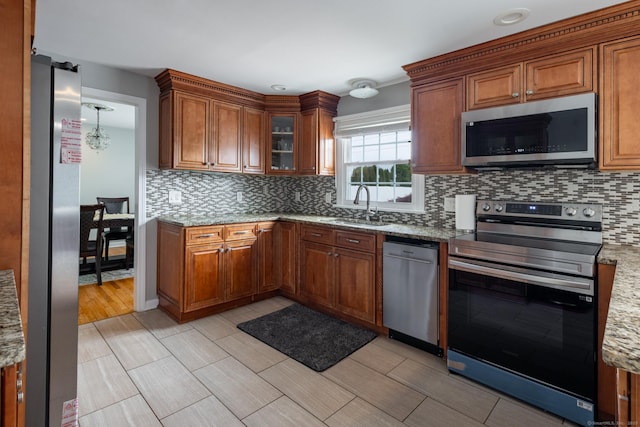 105 Reussner Rd, Southington, CT 06489 - kitchen with stainless steel appliances, a sink, brown cabinets, and decorative backsplash