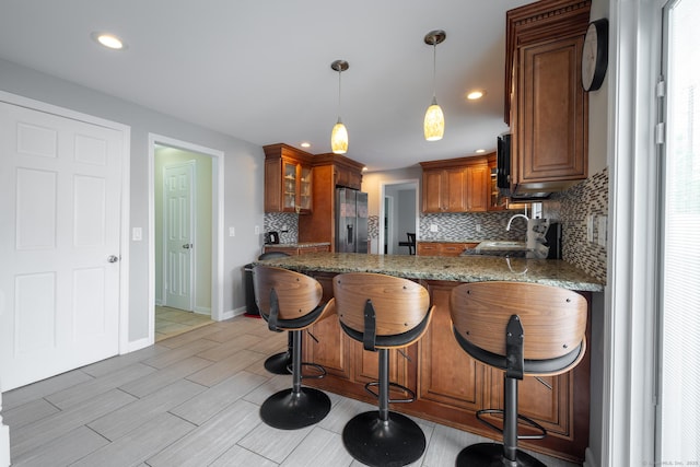 105 Reussner Rd, Southington, CT 06489 - kitchen featuring fridge with ice dispenser, tasteful backsplash, a peninsula, brown cabinets, and glass insert cabinets