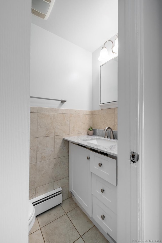 105 Reussner Rd, Southington, CT 06489 - bathroom with baseboard heating, tile walls, vanity, tile patterned floors, and toilet