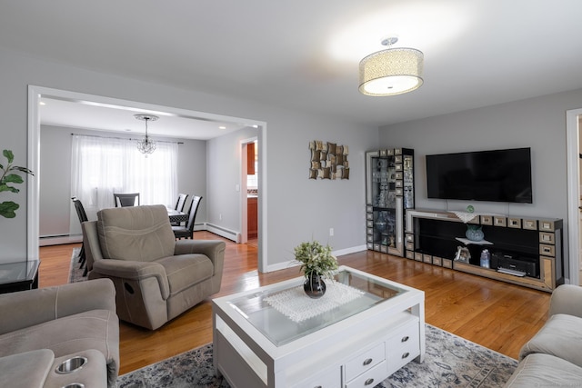 105 Reussner Rd, Southington, CT 06489 - living area with baseboard heating, a chandelier, wood finished floors, and baseboards