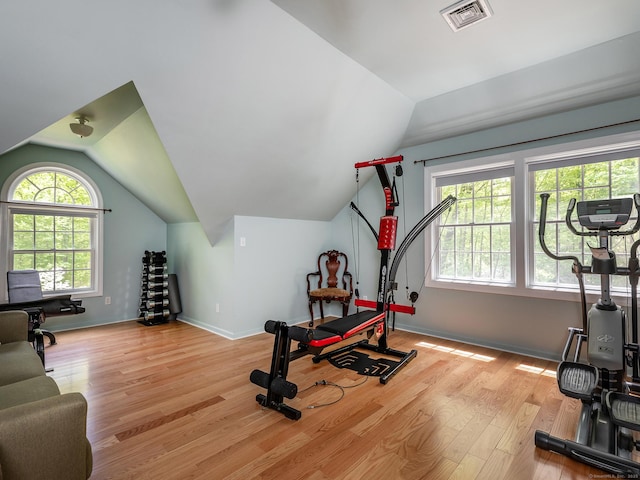 exercise area with lofted ceiling, wood finished floors, and baseboards