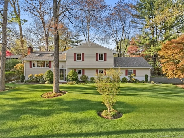 split level home featuring a front yard and a chimney