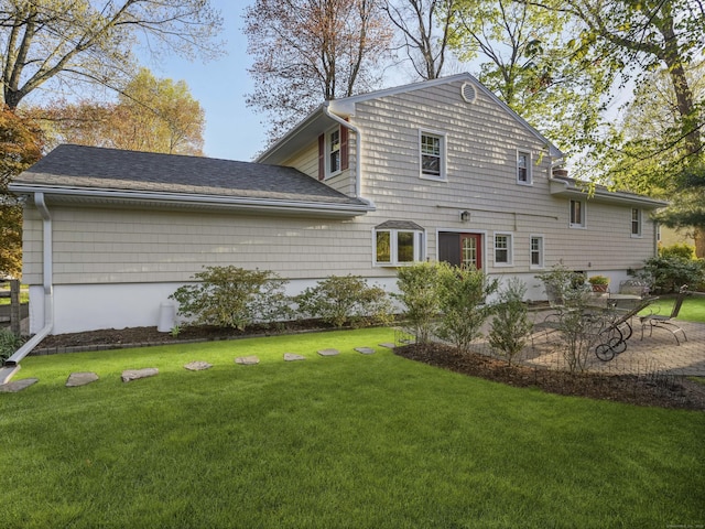 rear view of property with a yard and a patio area