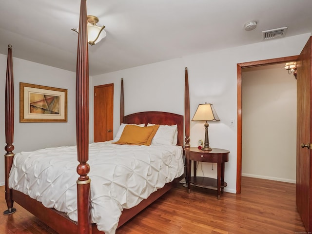 bedroom with wood finished floors and baseboards