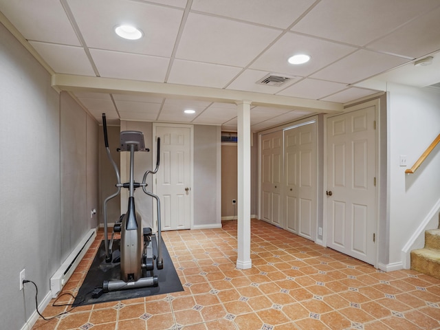 exercise area with a baseboard radiator, baseboards, recessed lighting, and a drop ceiling