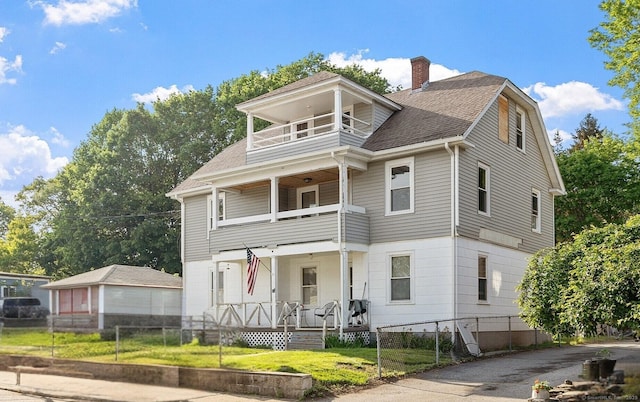 14 Palmer St, Killingly, CT 06239 - view of front of property with a balcony, a fenced front yard, a chimney, covered porch, and roof with shingles