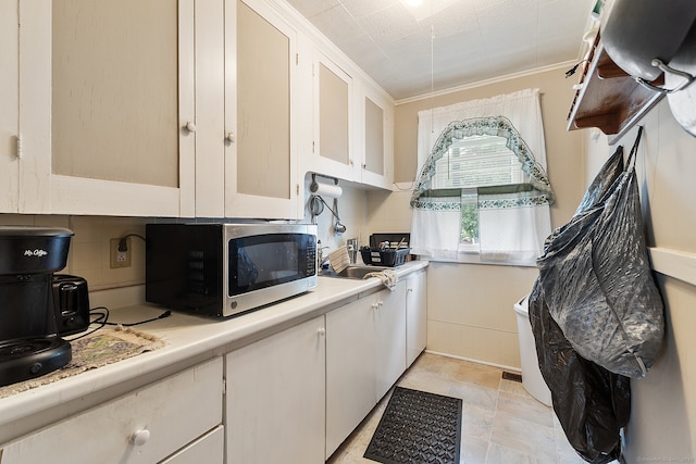 14 Palmer St, Killingly, CT 06239 - kitchen with stainless steel microwave, light countertops, white cabinets, a sink, and ornamental molding