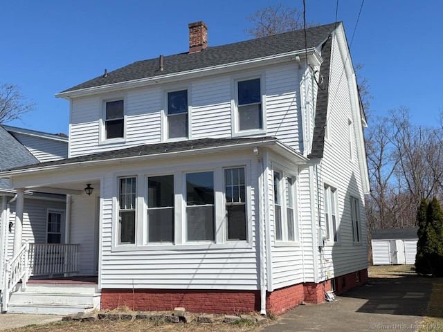 273 Peck Ave, West Haven, CT 06516 - view of front of property featuring an outbuilding, a chimney, a shed, roof with shingles, and covered porch