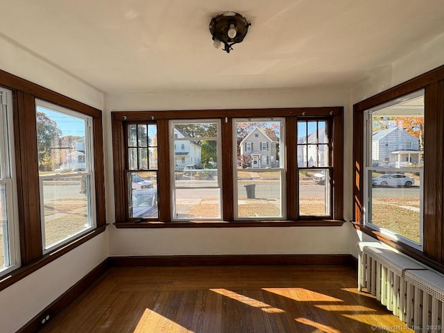 273 Peck Ave, West Haven, CT 06516 - unfurnished sunroom featuring baseboards, radiator, and wood finished floors