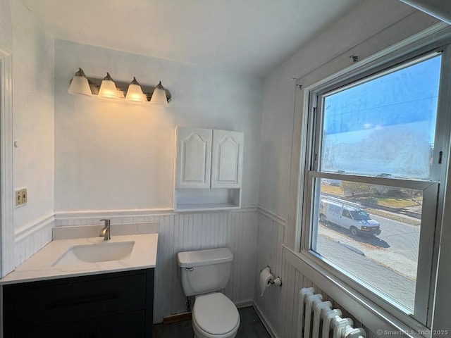 273 Peck Ave, West Haven, CT 06516 - half bathroom featuring a wainscoted wall, toilet, radiator heating unit, and vanity