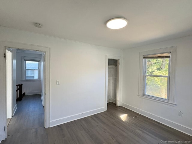 273 Peck Ave, West Haven, CT 06516 - unfurnished bedroom featuring dark wood finished floors, multiple windows, and baseboards