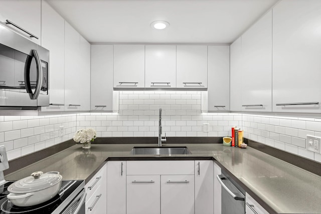 4 Coggswell St Unit 2, Stonington, CT 06379 - kitchen with appliances with stainless steel finishes, a sink, backsplash, and white cabinetry